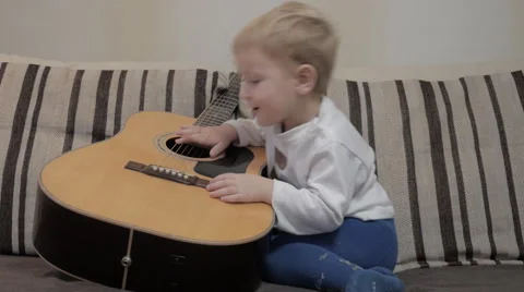 The child plays the guitar Video stock 42369324