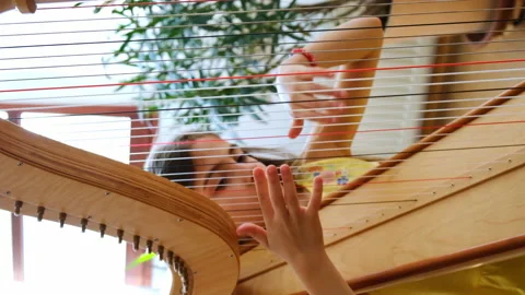 The child plays the harp. Selective focus. Stock Footage 196752476