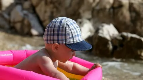 Child plays in the inflatable pool on the seashore. Stock Footage 11939953