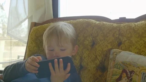 Child plays with mobile device Video stock 76547032