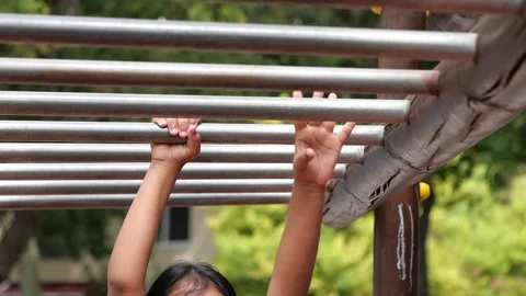 Child plays on monkey bars at a local park Stock Footage 325441925