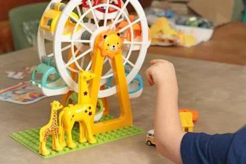 Child plays with a plastic constructor at home on table. Children and Stock Photos
