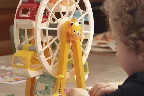 Child plays with a plastic constructor at home on table. Children and Stock Photos