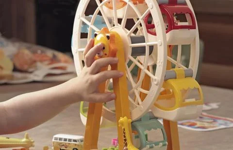 Child plays with a plastic constructor at home on table. Children and Stock Photos