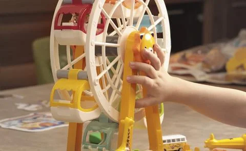 Child plays with a plastic constructor at home on table. Children and Stock Photos