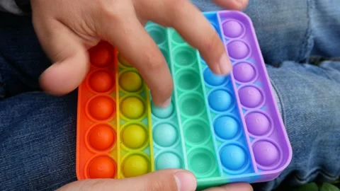 Child plays with pop it, presses the silicone bubbles with his finger Stock Footage 155706743