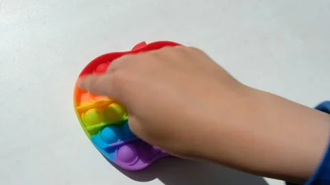 A child plays with pop it sensory toy simple dimple. Stock Footage 155970081