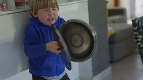 A child plays with pot lids Stock Footage 146313857