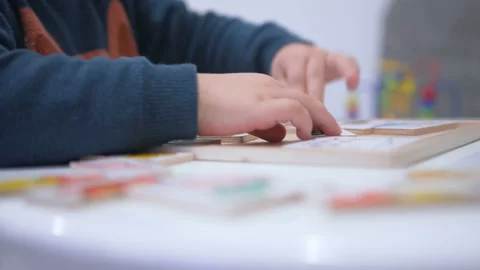 Child plays with a puzzle. Close up hands Stock Footage 104044875