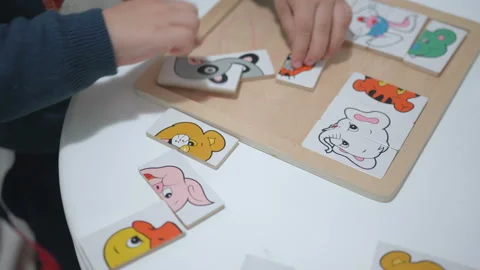 Child plays with a puzzle. Close up hands Stock Footage 104047639