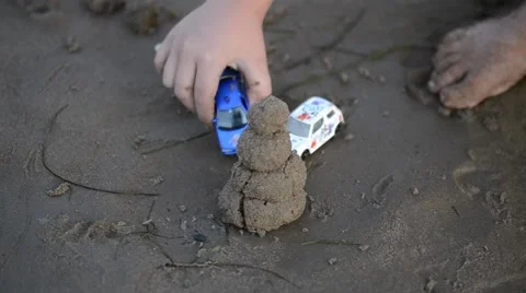 A child plays in the sand at the beach Stock Footage 56035603