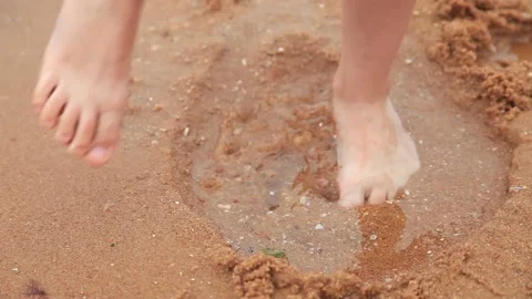 A child plays with sand on the beach Stock Footage 140506646