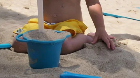 A child plays in the sand on the beach Stock Footage 280703293