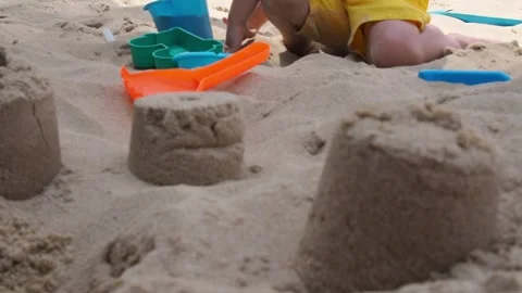 A child plays in the sand on the beach Stock Footage 281795173