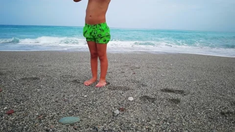 Child plays on the sand of a beach looking at the sea Stock Footage 161007646