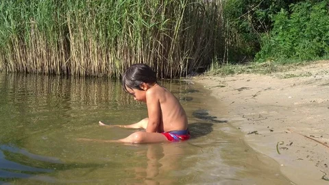 Child plays with sand in the river Stock Footage 93330047