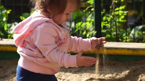 A child plays in a sandbox in the backlight of the sun Stock Footage 138681980
