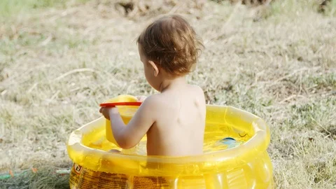 Child plays in a small inflatable pool Stock Footage 89552057
