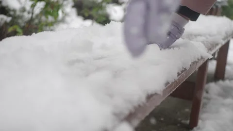 Child plays with snow on a table in winter Stock Footage 335501081