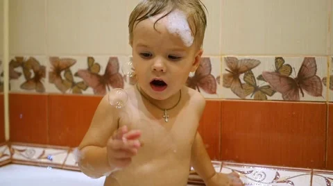 A child plays with soap bubbles in the bathroom Stock Footage 65162541