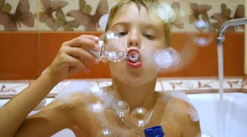 A child plays with soap bubbles in the bathroom Video stock 65313909