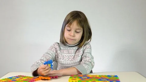 The child plays with soft multi-colored puzzles. Soft mat in the form of piec Stock Footage 122571620