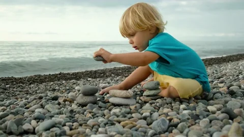 A child plays with stones on the beach. Stock Footage 200807519