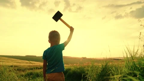 Child plays superhero from comic book, child holds hammer in his hand, Child Stock Footage 194603078