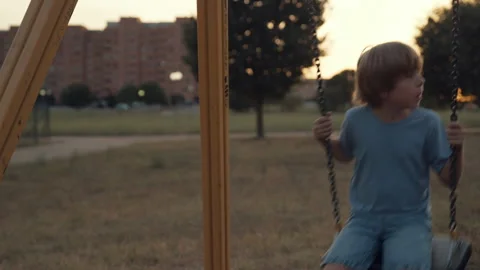 A child plays with the swing on the playground Stock Footage 255204399