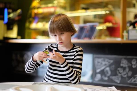 A child plays at a table in a cafe Stock Photos