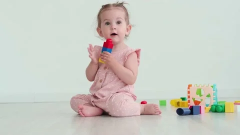 Child plays using toy blocks and rejoices clapping his hands Stock Footage 156473238