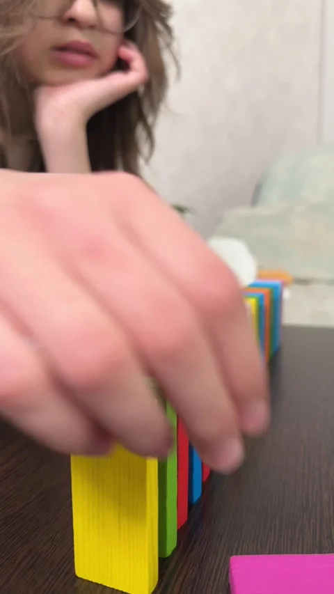 The child plays using wooden cubes, creating towers and buildings, Stock Footage 244656721