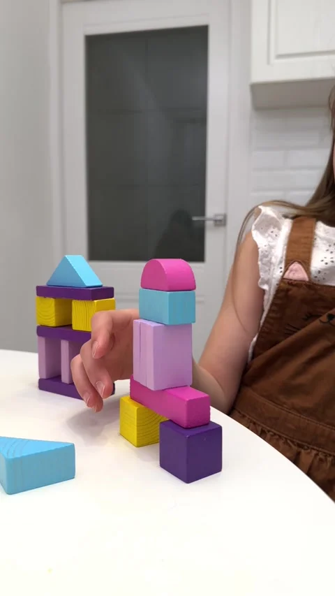 The child plays using wooden multi-colored blocks, creating towers and buildings Stock Footage 240633113
