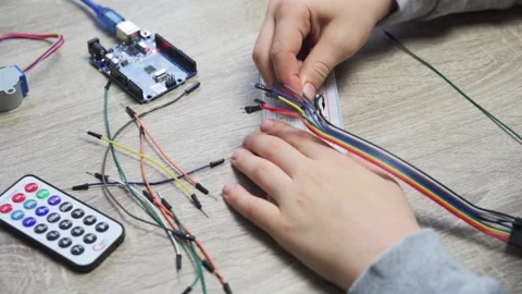 A child plugging cables to sensor chips while learning arduino coding and Stock Footage 167843959