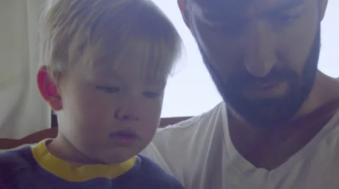 Child points out thing on cell phone to dad Stock Footage 64385163