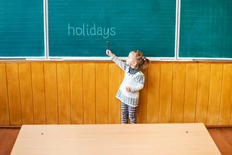 Child points to a school board Stock Photos