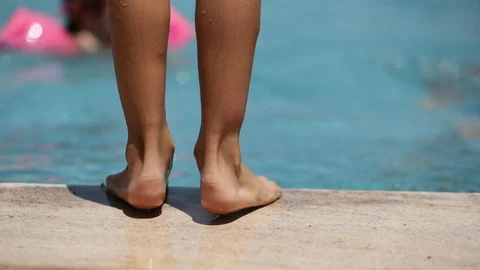 Child by the poolside waiting to jump in... | Stock Video | Pond5