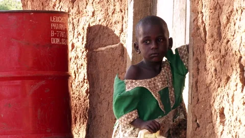 Child portrait Uganda EXT 4 at door with oil drum Stock Footage 133912251