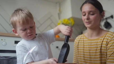 Child pouring drainage material into pot using shovel before planting seedlings Stock Footage 331438105