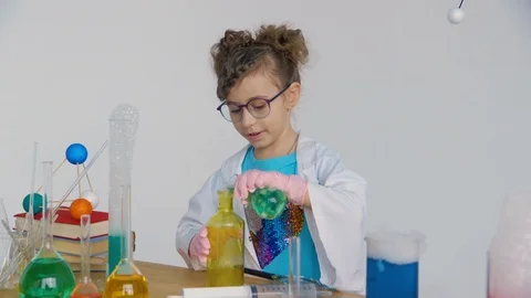 A child pours a chemical solution from one test tube to another Stock Footage 90097716