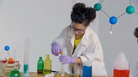 A child pours a chemical solution from one test tube to another Stock Footage 90097918