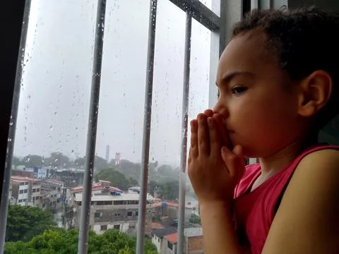 Child praying in window Stock Photos