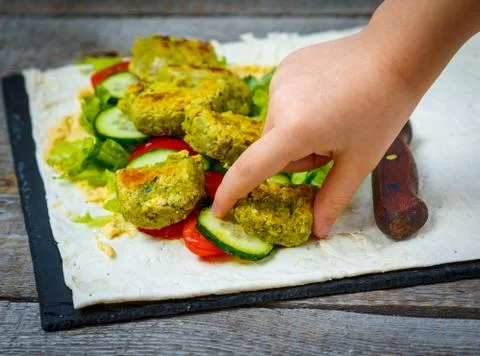 The child is preparing falafel Stock Photos