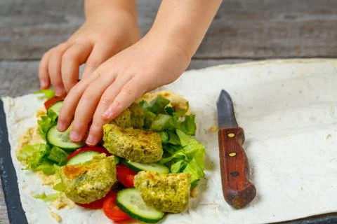 The child is preparing falafel Stock Photos