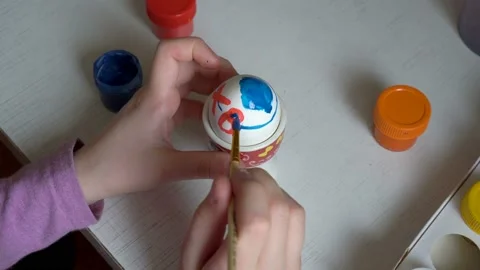 The child is preparing for the holiday and draws on the Easter egg symbols of Video stock 103159073