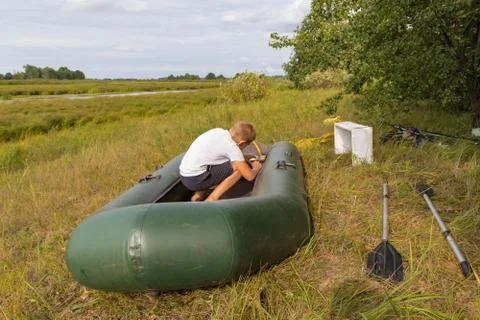 A child is preparing an inflatable boat Stock Photos