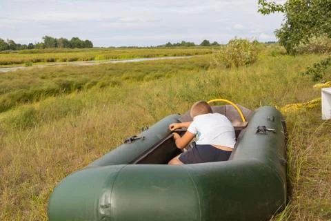 A child is preparing an inflatable boat Foto stock