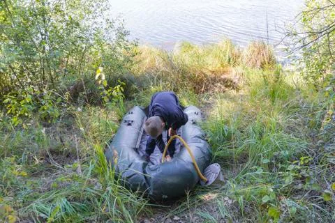 A child is preparing an inflatable boat Stock Photos