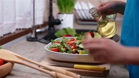 Child preparing a vegetable salad - pouring oil Stock Footage 77679145
