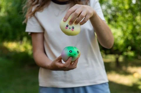 Child presenting two colorful dumpling squishy toys. Stock Photos